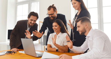 Personas al frente de un computador haciendo el gesto de saludo