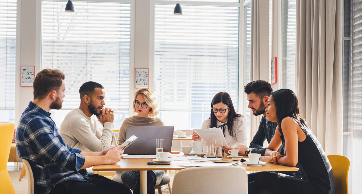 personas reunidos alrededor de una mesa con computadores