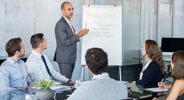 Persona explicando en un tablero en una reunión en la oficina