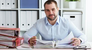 Persona sonriendo a la cámara con un cuaderno abierto